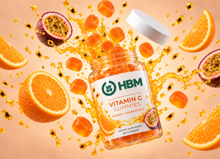 Fine white vitamin C powder with sliced citrus, amber laboratory glassware and stainless-steel supplement manufacturing equipment.
